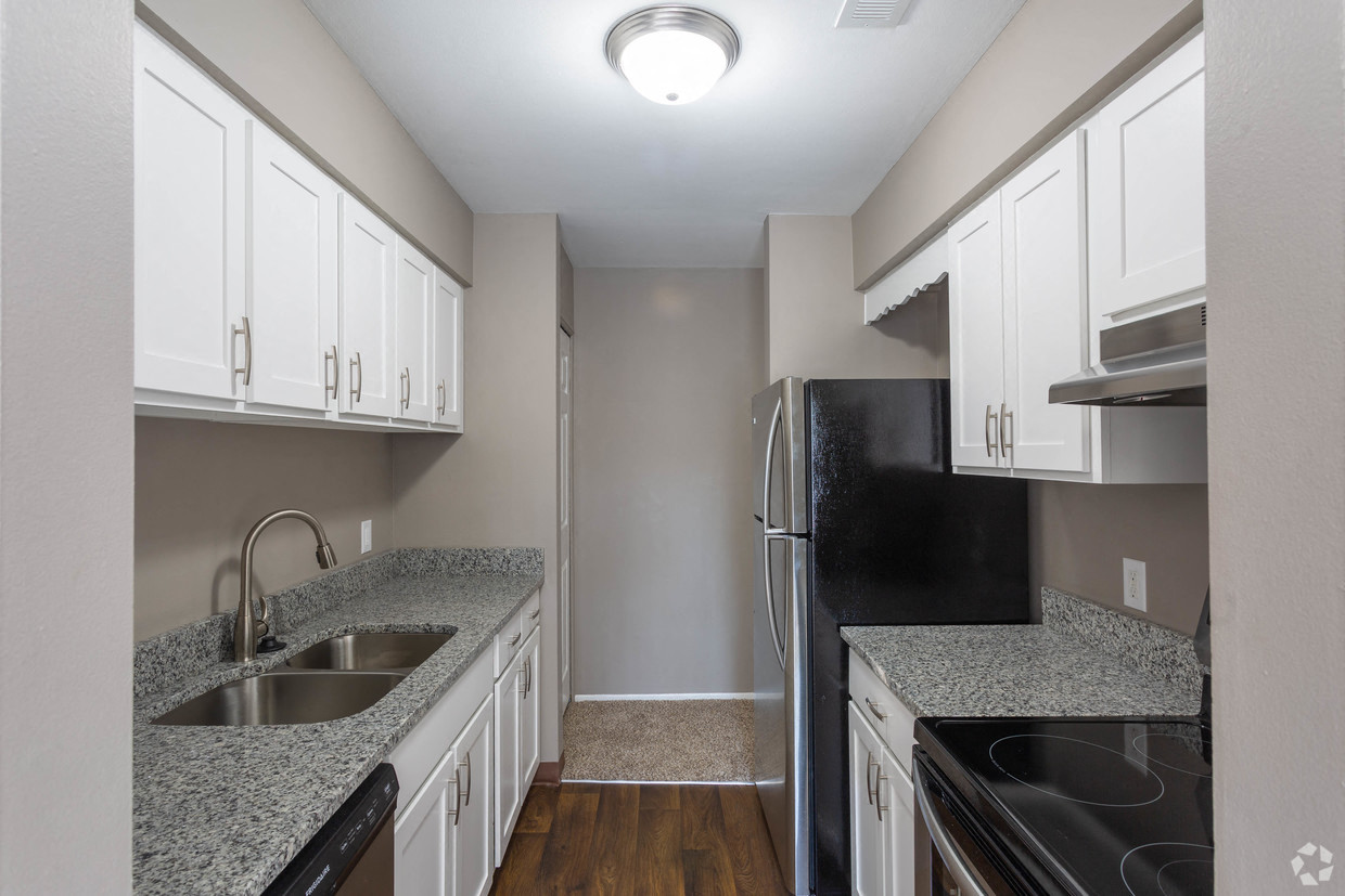 a kitchen with granite counter tops and a stainless steel refrigerator